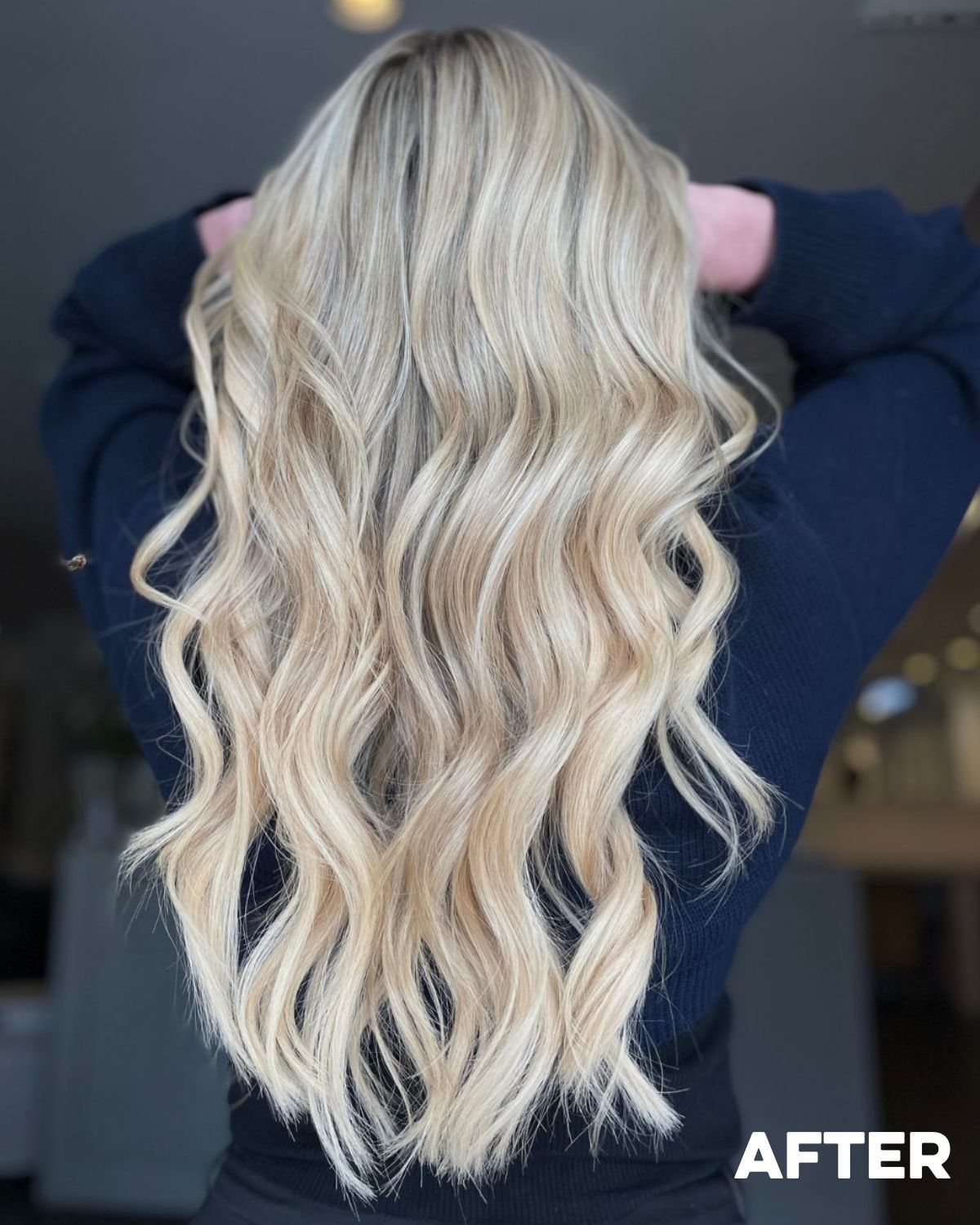 Blonde wavy hair styled down a woman’s back.