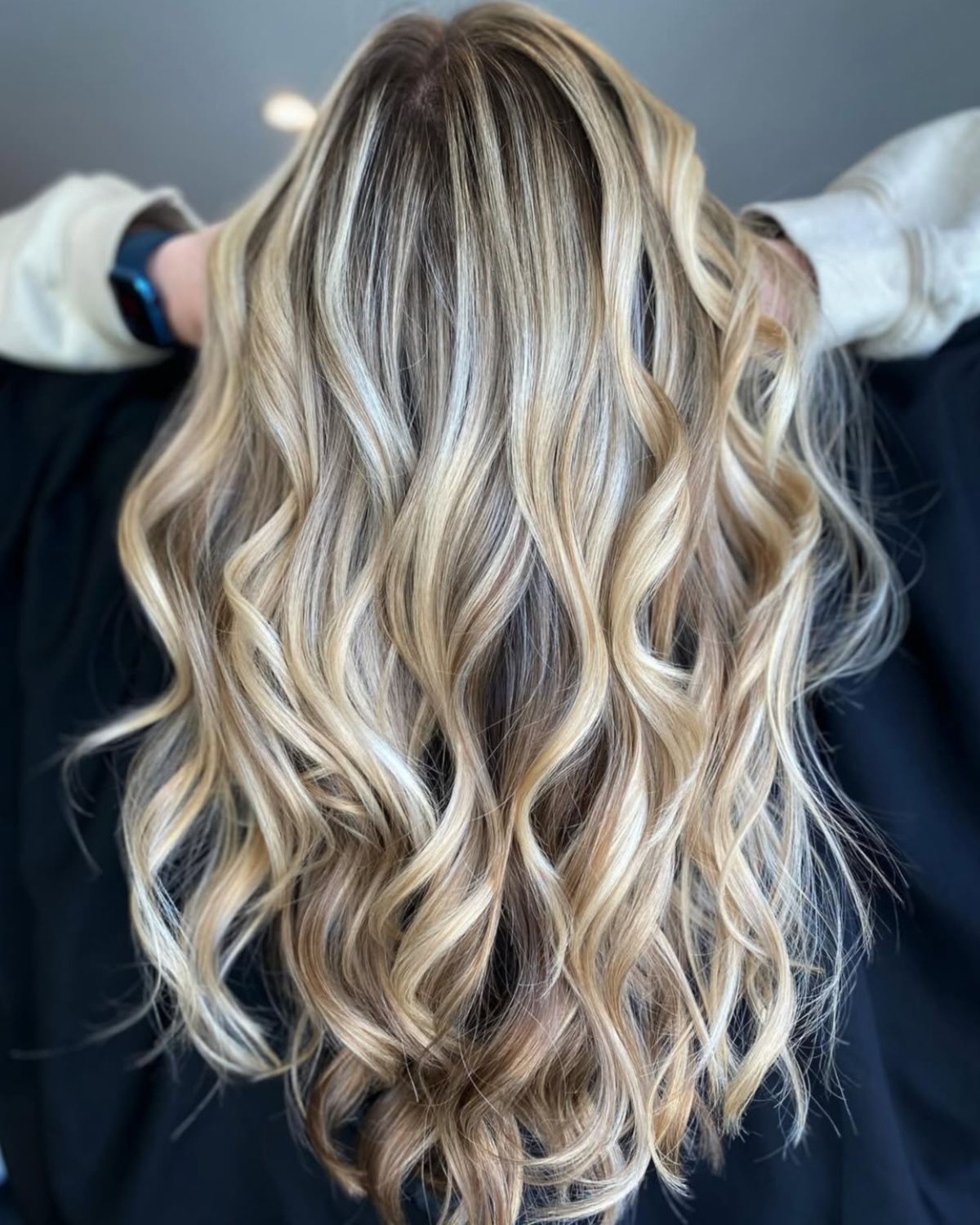 Blonde hair styled in waves with highlights.