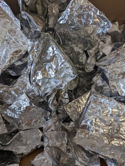 A pile of crumpled aluminum foil is sitting on a table.