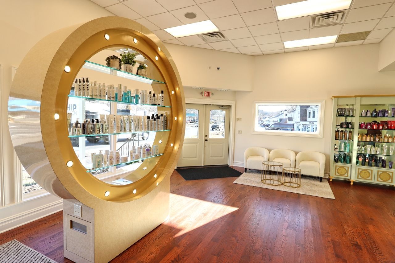Salon interior with display of products, seating, and wooden floors.