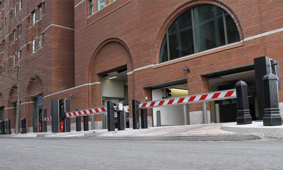 Red-and-white striped barrier blocking a brick building driveway entrance