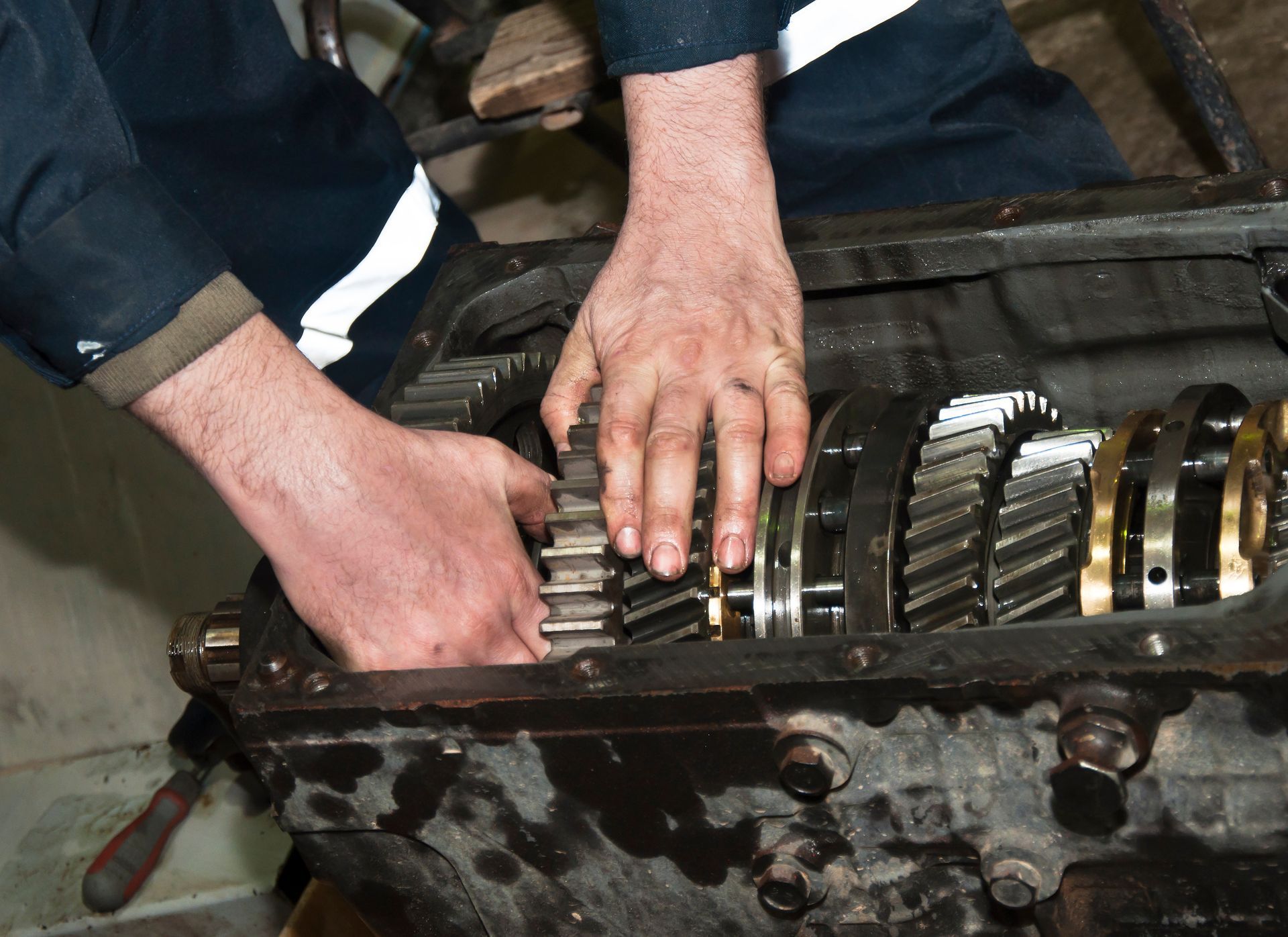 Car transmission repair with a mechanic adjusting internal gears. Car transmission repair with a mechanic adjusting internal gears.
