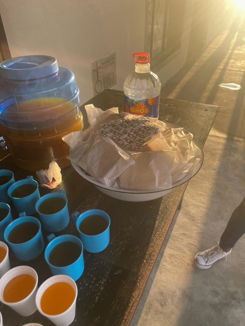 A table with a bowl of food and a bottle of water on it.