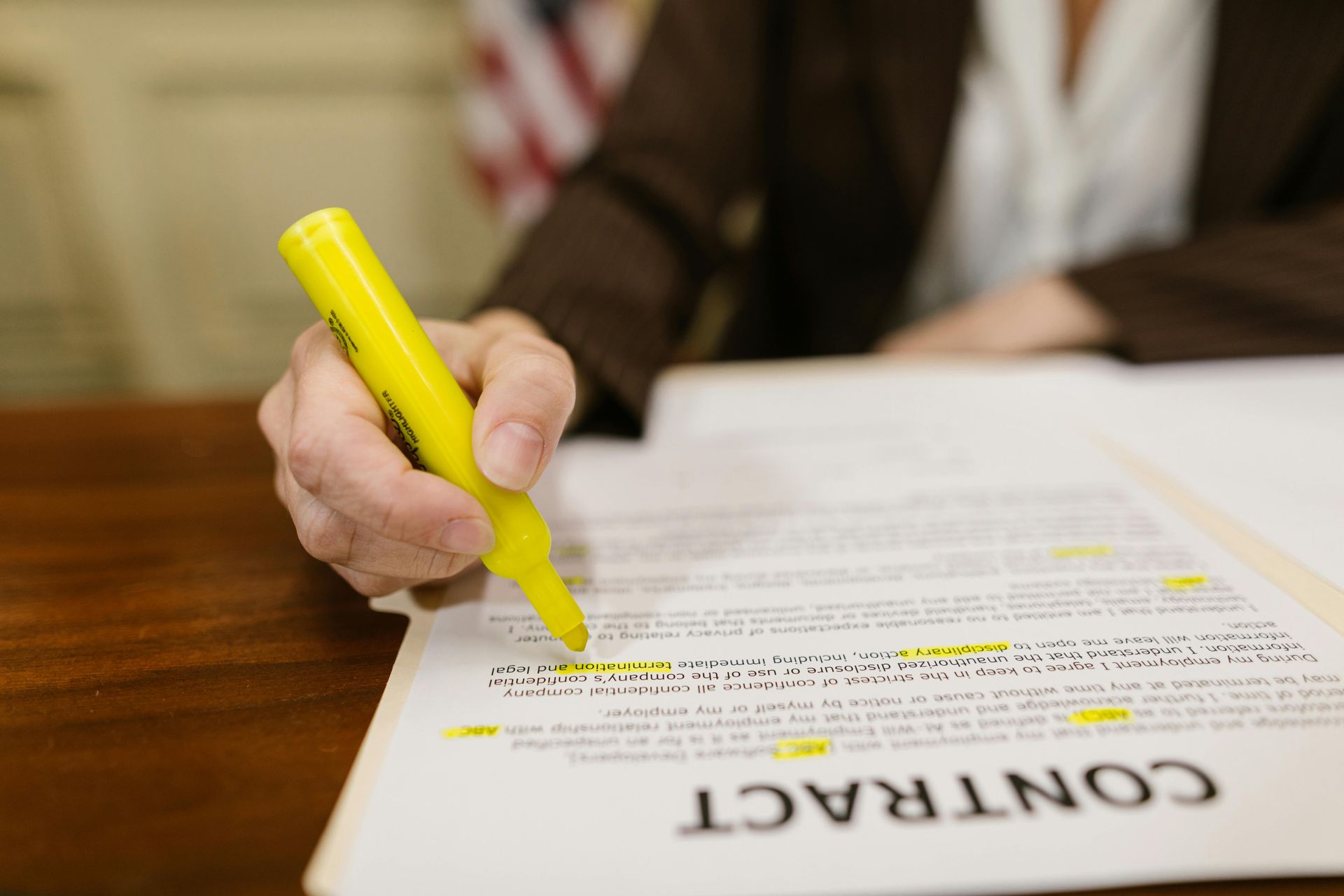 A startup lawyer is writing on a piece of paper with a yellow marker.