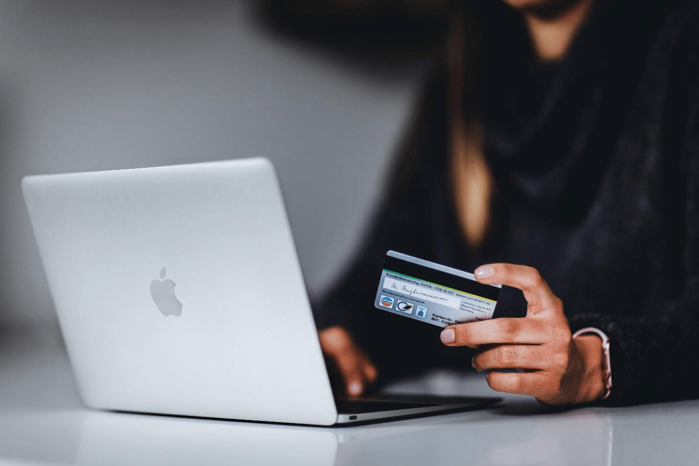 A person using their credit card on their laptop.