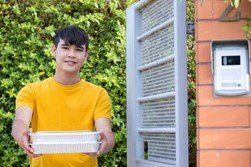 a man in a yellow shirt holding a food parcel
