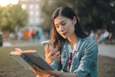 : A girl using phone while reading