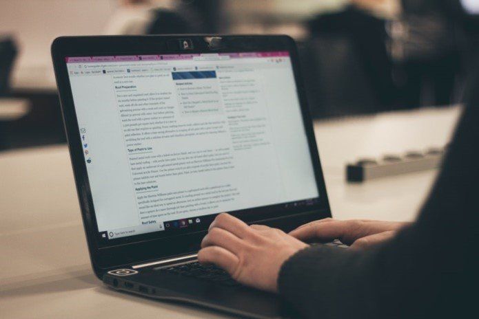 a person writing a blog on a laptop