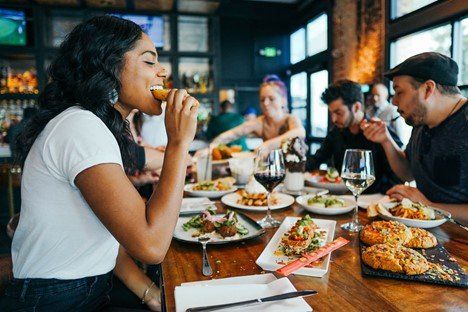A woman is happily eating out with friends