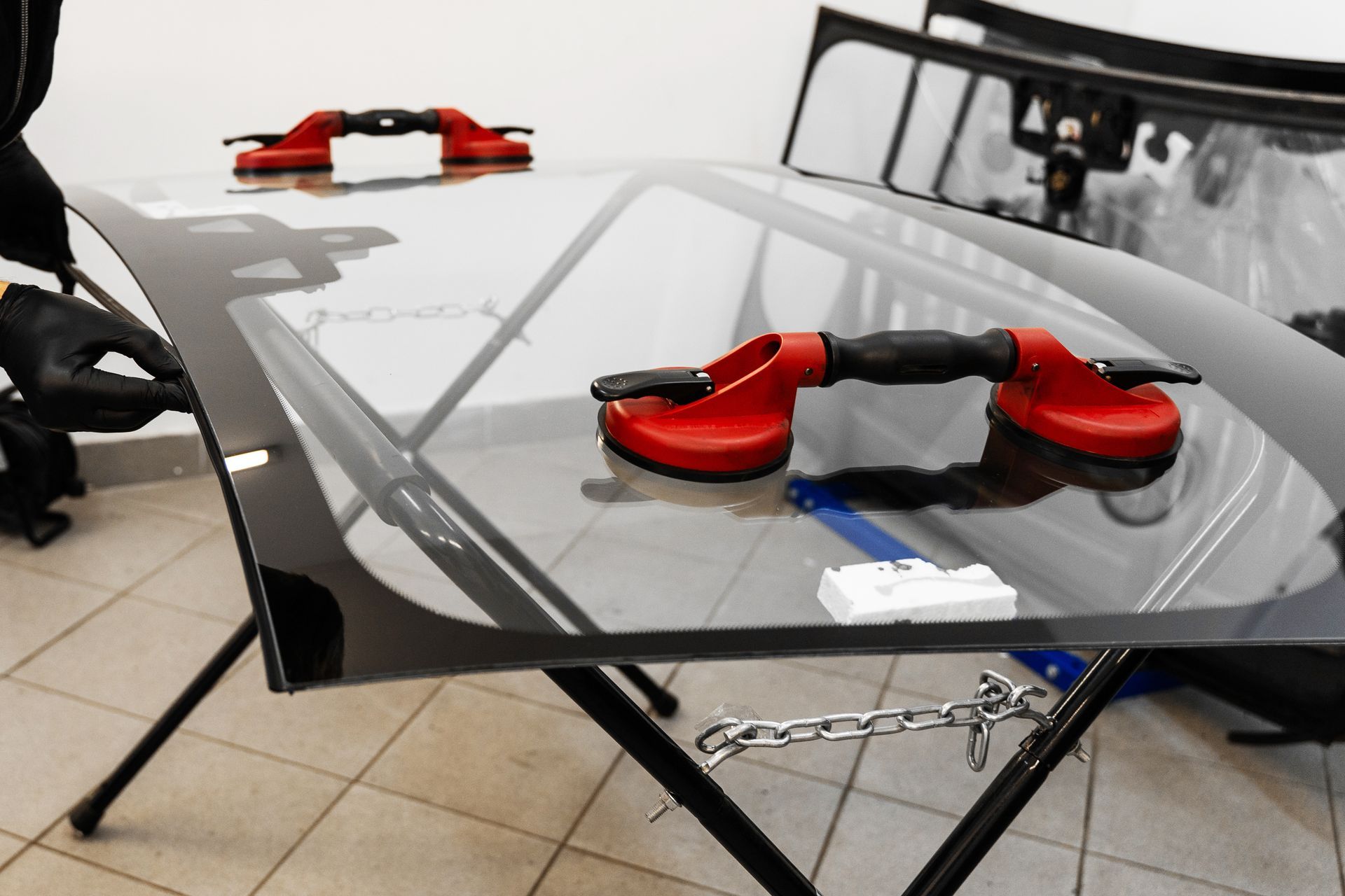 Glass coffee table with red corner supports in a tiled room