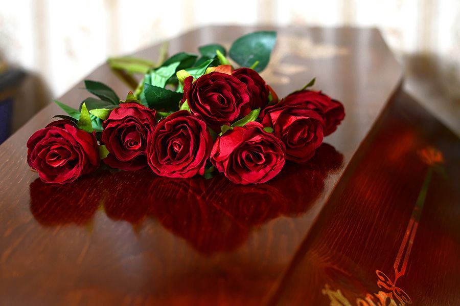 Red roses on a wooden coffin.