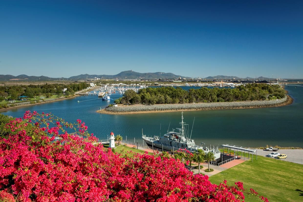 A View of a Body of Water With Boats in It and Flowers in the Foreground — Yeppoon Denture Clinic in Gladstone, QLD