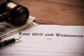 Gavel, dollar bills, and a document titled “Last Will and Testament” on a wooden desk. — Willmar, MN — Schneider & Madsen PC Gavel, dollar bills, and a document titled “Last Will and Testament” on a wooden desk. — Willmar, MN — Schneider & Madsen PC