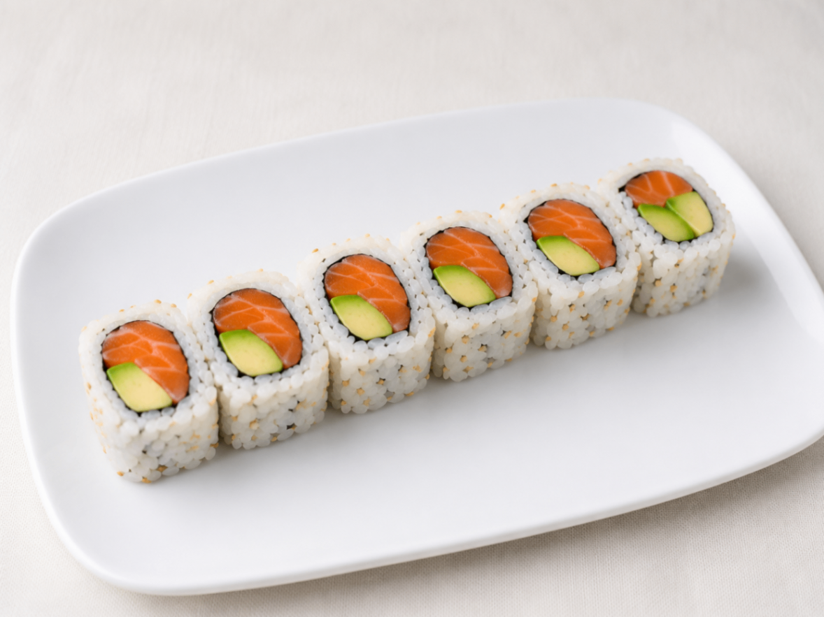 Sushi rolls with avocado and salmon on a white plate