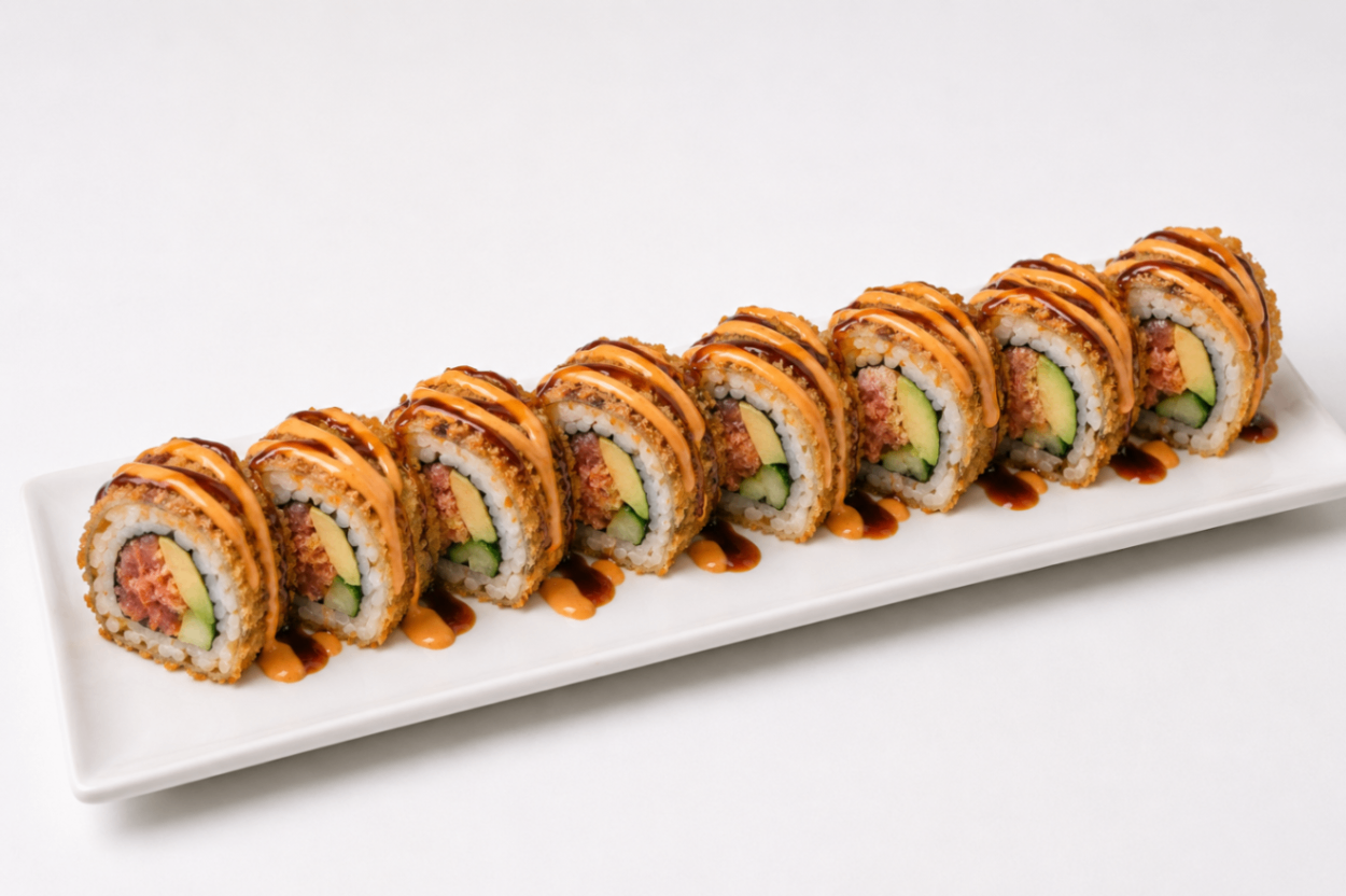 Assorted sushi rolls arranged in a row on a white rectangular plate
