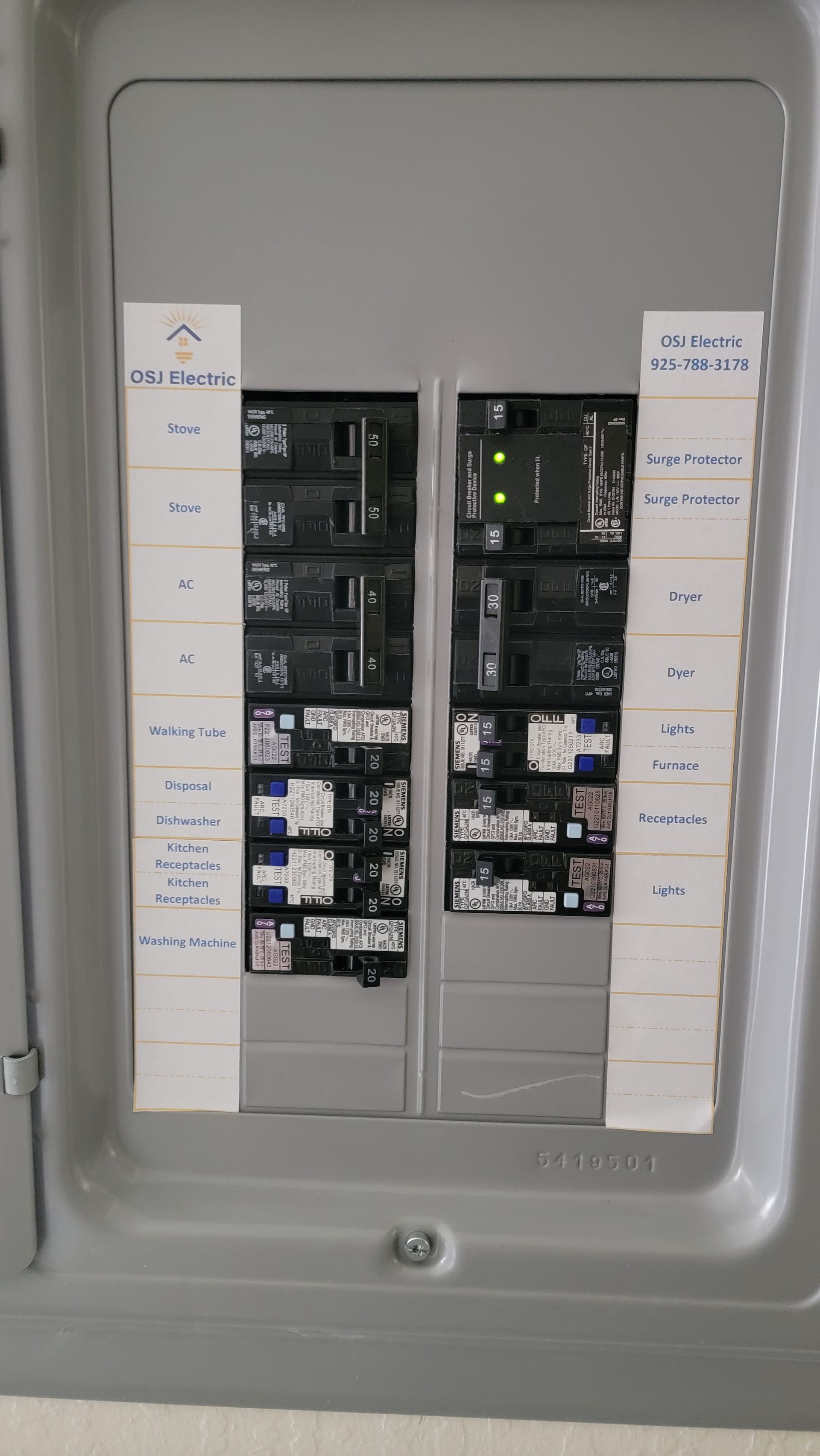 Electrical circuit breaker panel with labeled switches and a gray metal cover removed