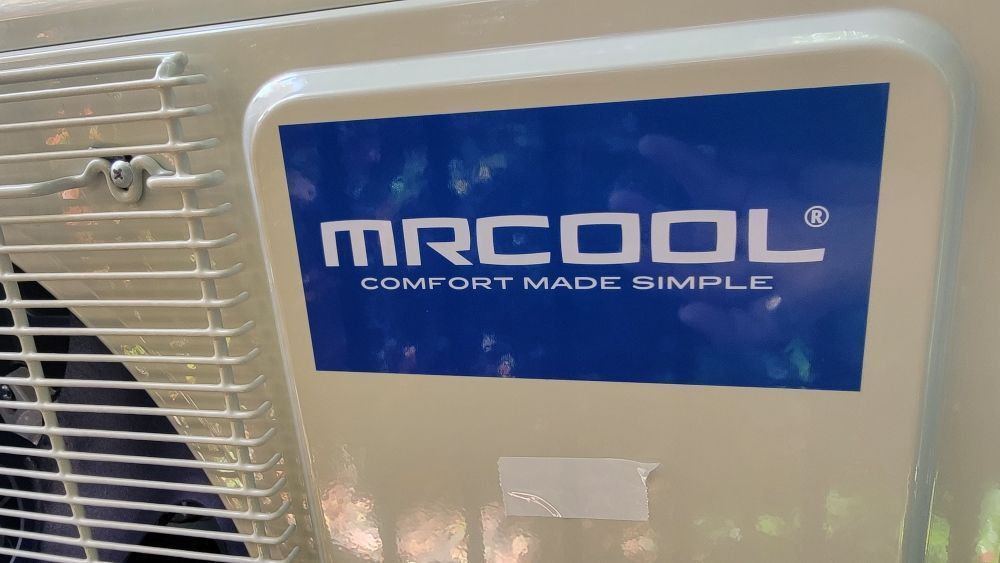 Blue MRCOOL air conditioner unit with white grille and “Comfort Made Simple” logo