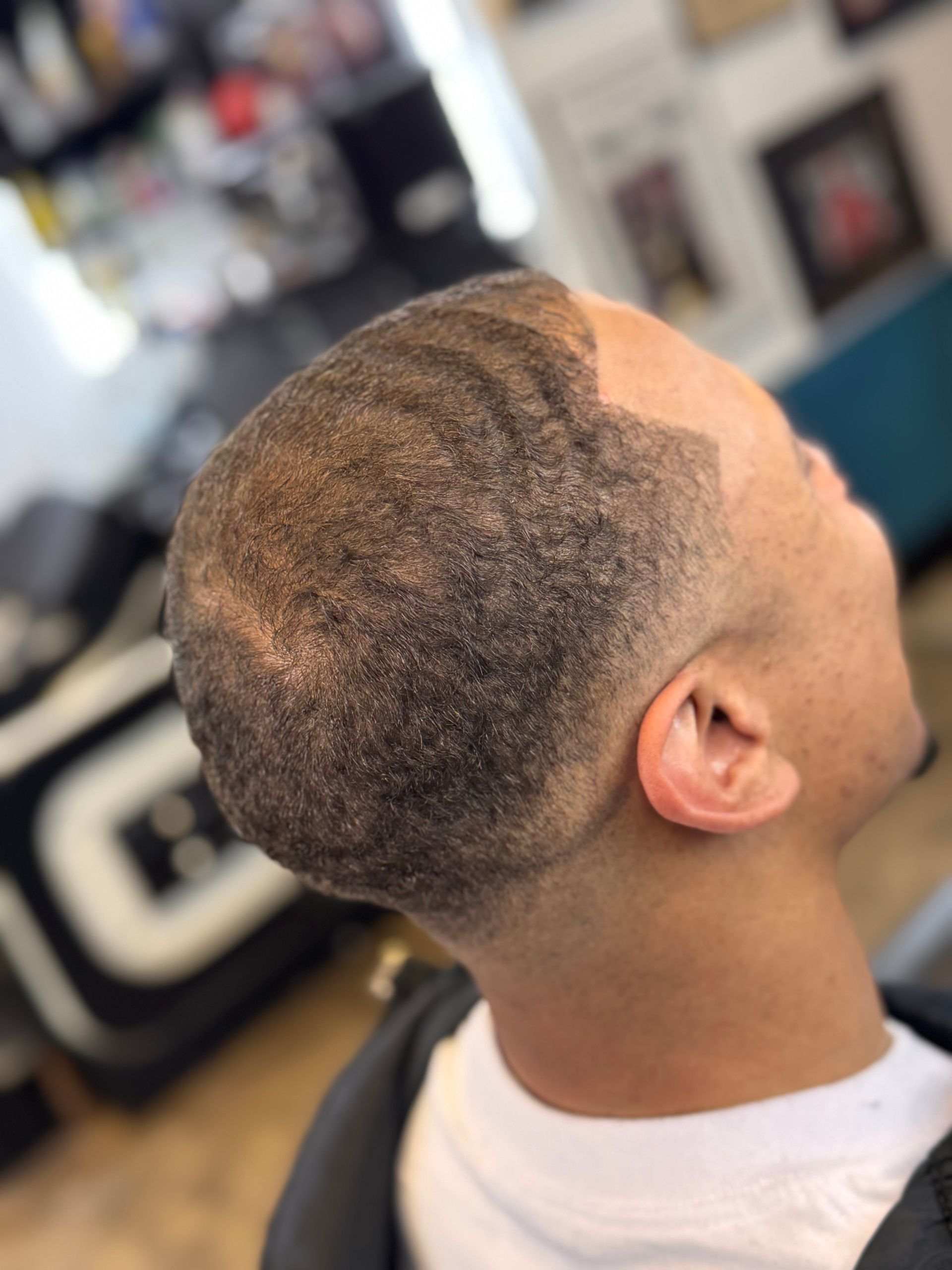 A man is getting his hair cut at a barber shop