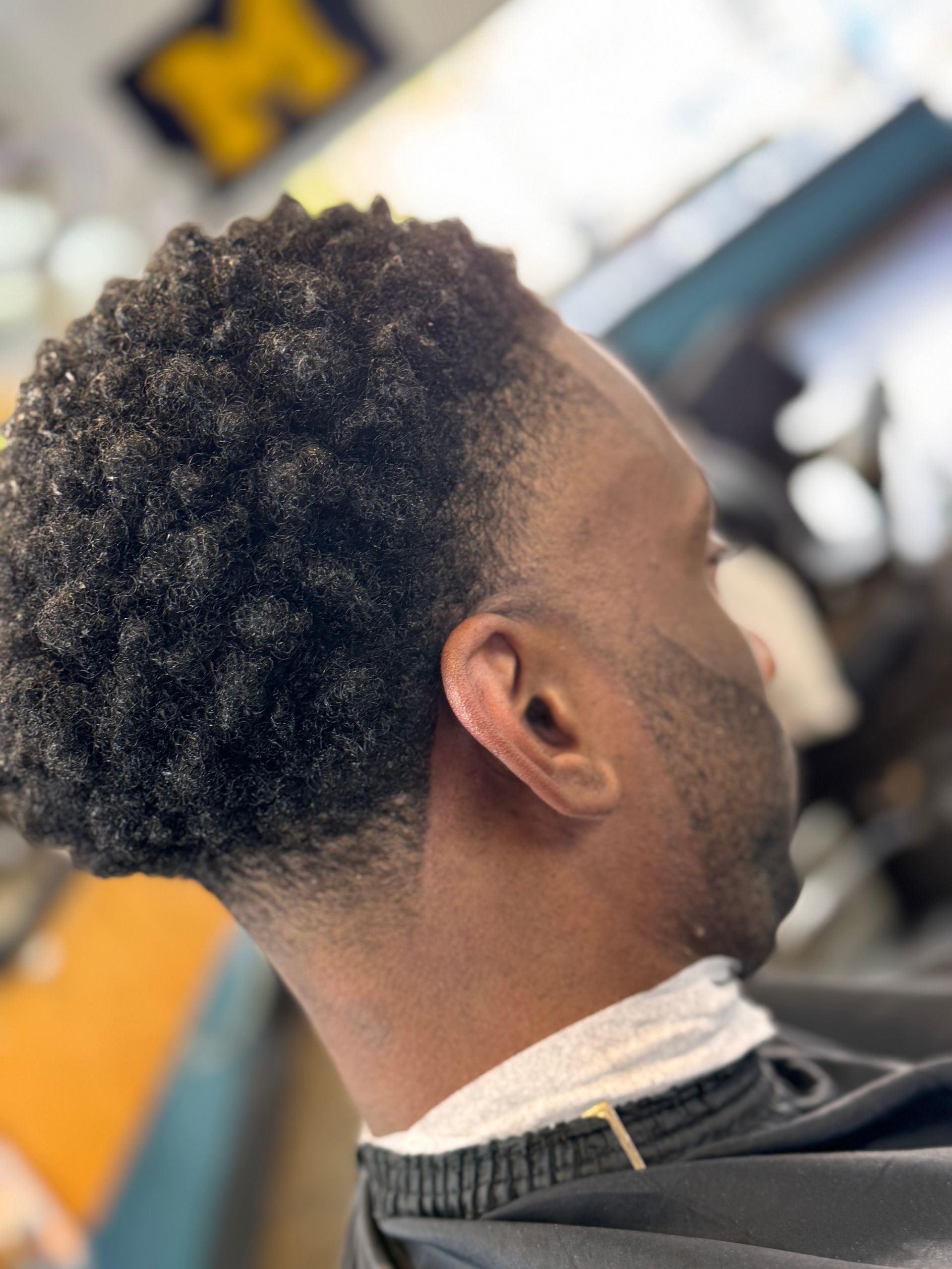 A man is getting his hair cut at a barber shop