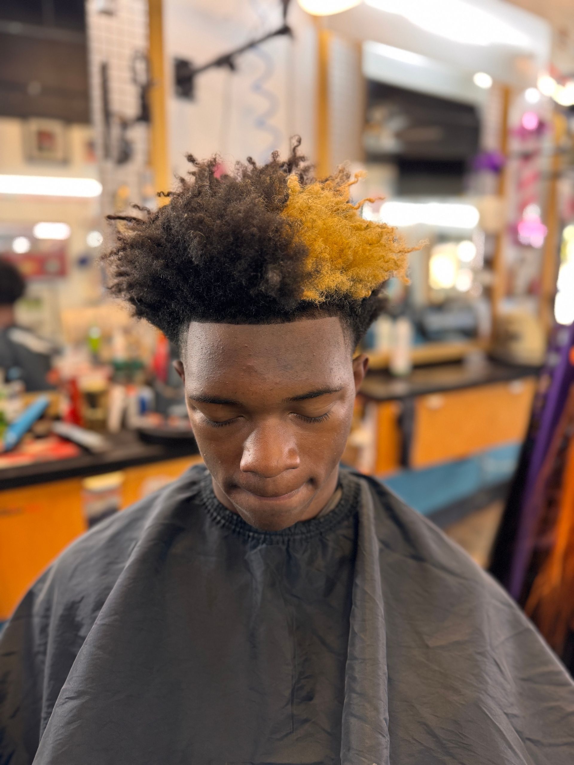 A man is getting his hair cut at a barber shop.