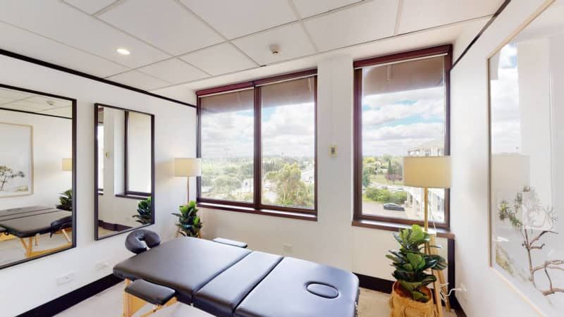 There is a massage table in the middle of the room.