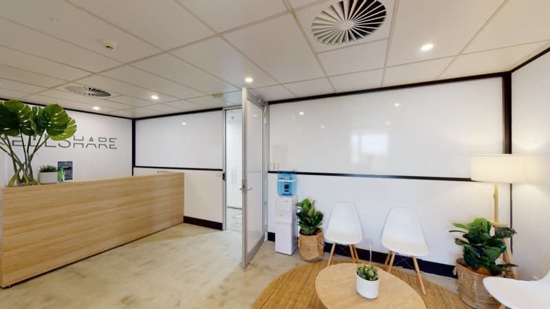 A waiting room with a desk , chairs , and a table.