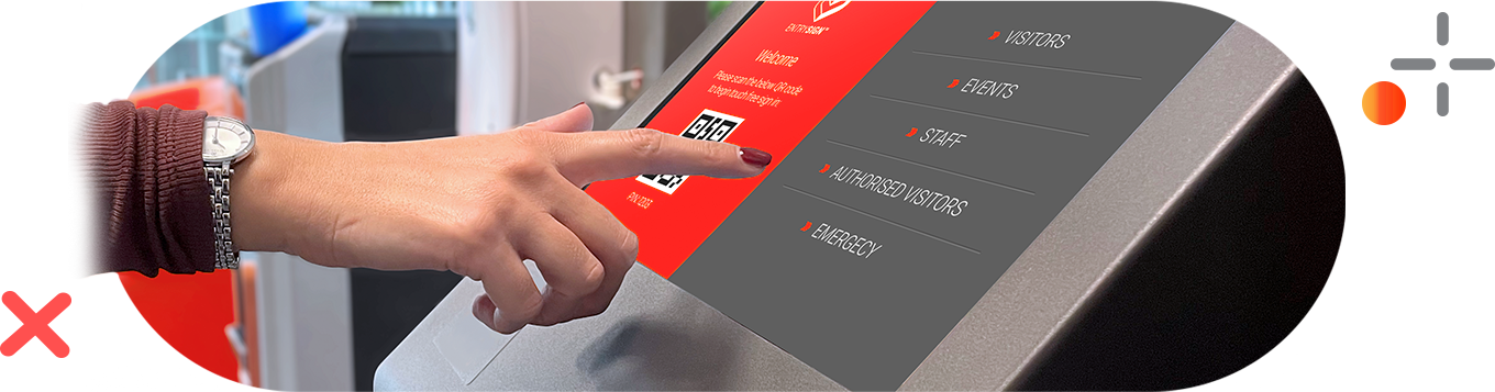 A hand touches a screen with a QR code. The screen is on a silver kiosk.