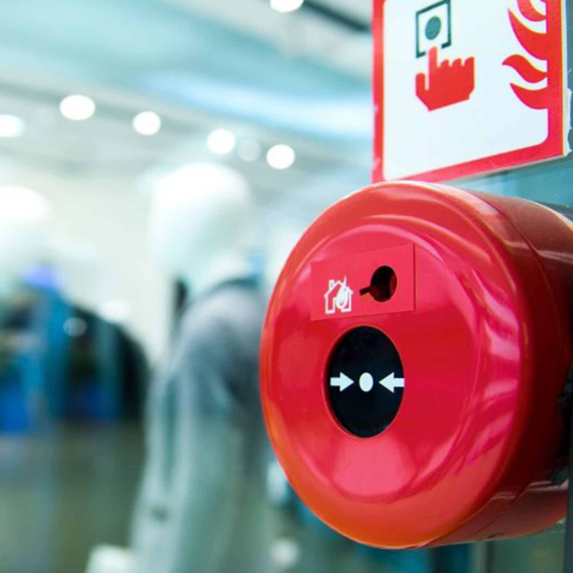 Red fire alarm pull station with instructions in a building.