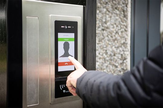 Person using intercom with screen showing silhouette and 