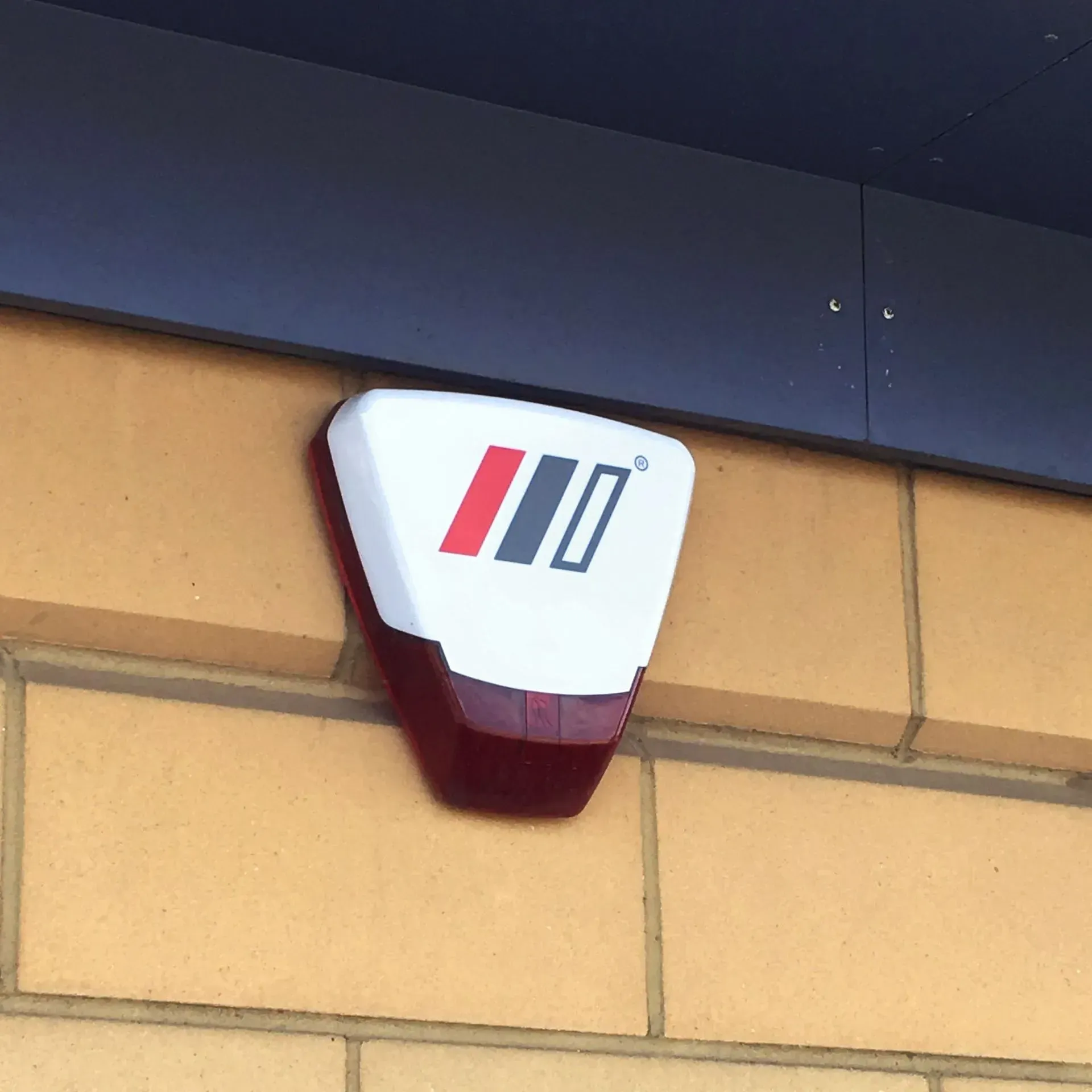 White and red security alarm with the logo