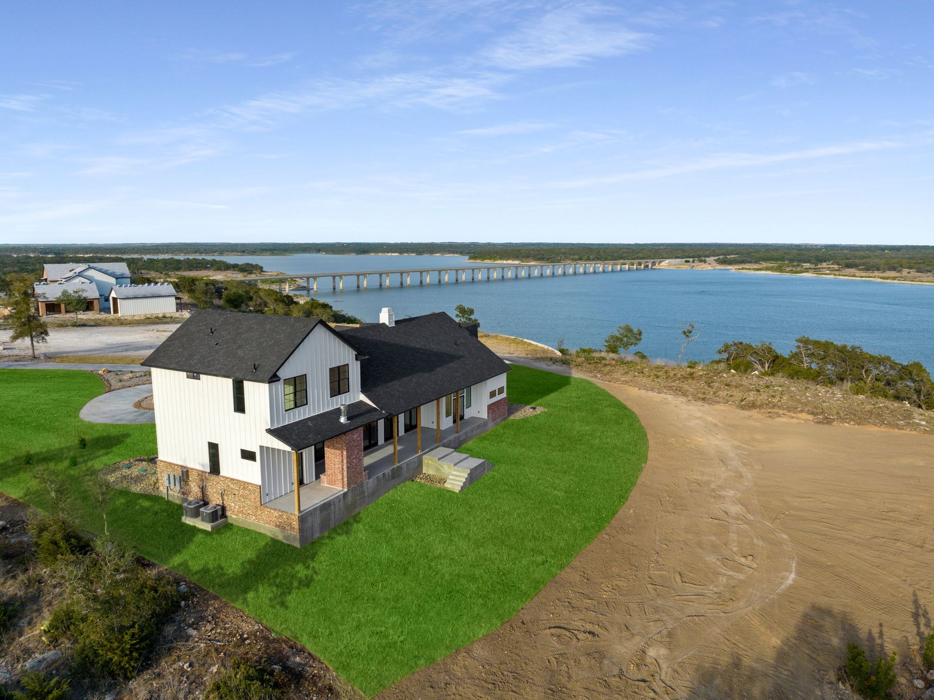 White house by the sea on a grassy hill under a blue sky