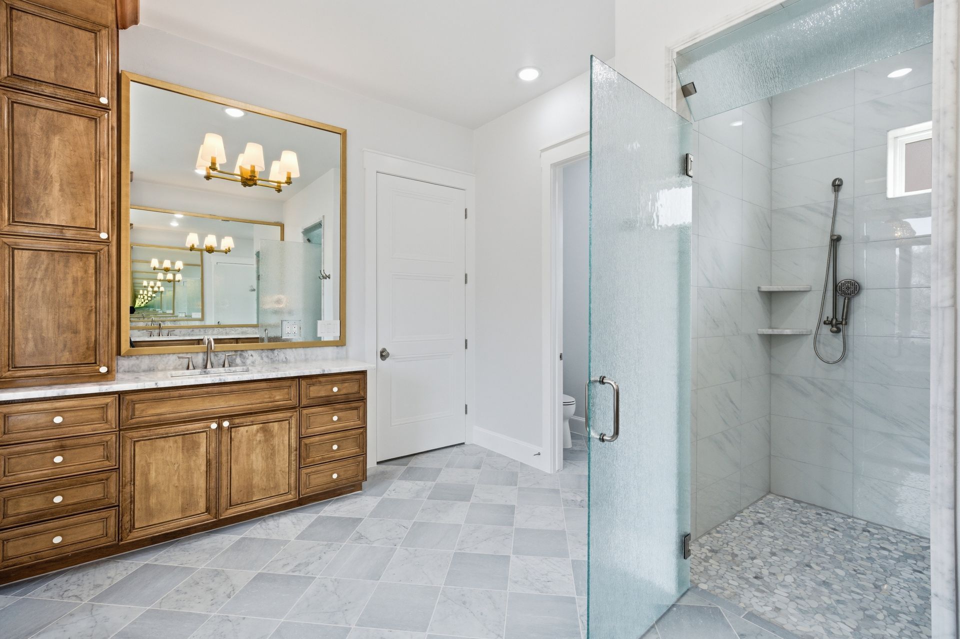 Luxurious bathroom with double vanity, large mirror, and glass walk-in shower