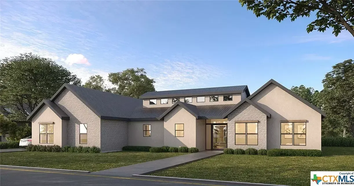 Modern single-story house exterior with stone facade, dark roof, and large windows at dusk