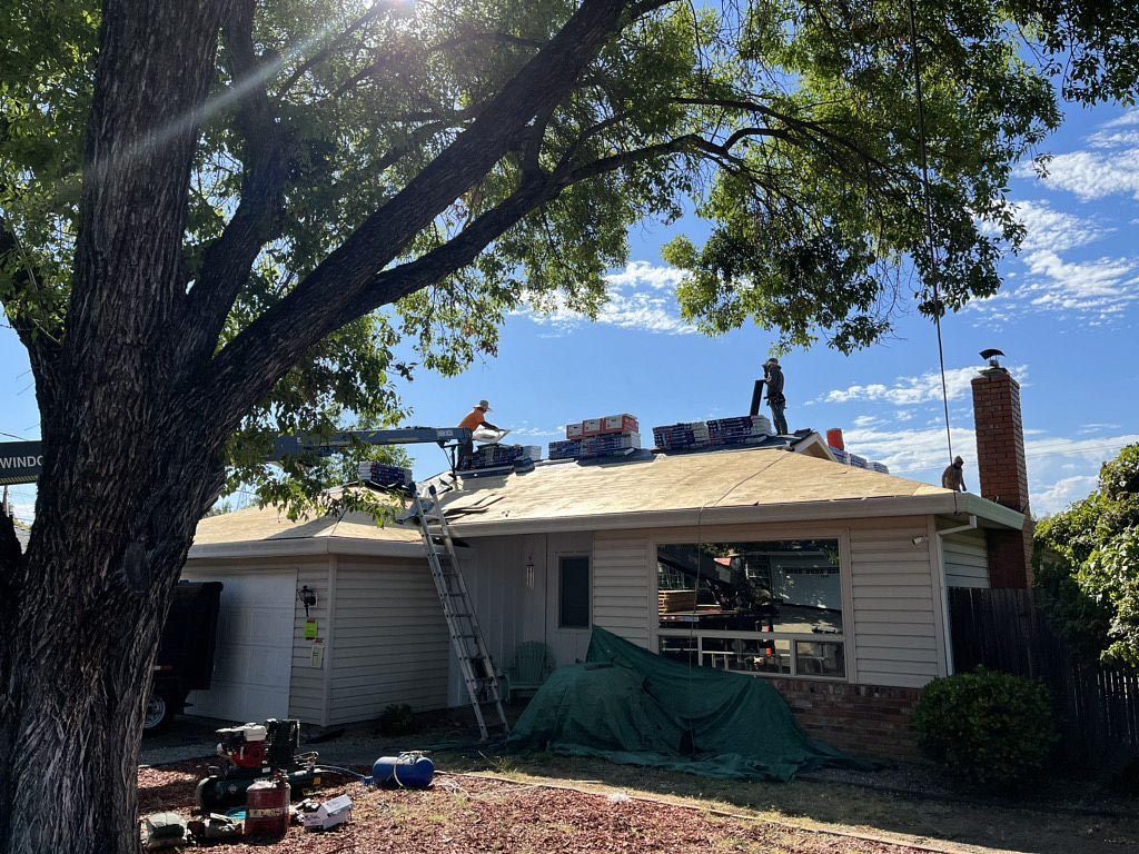 Fire-damaged house with a tree in front, collapsed roof, and debris in the yard