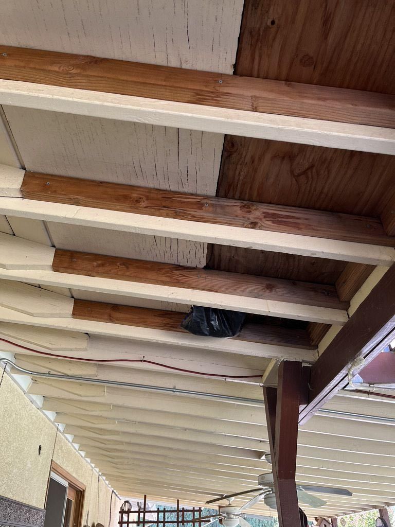 Covered porch ceiling with exposed wooden beams and hanging fabric panels