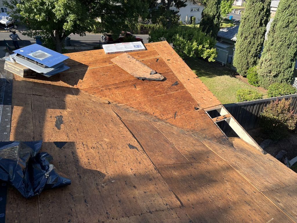 Roof under repair with exposed plywood and roofing materials on a residential house