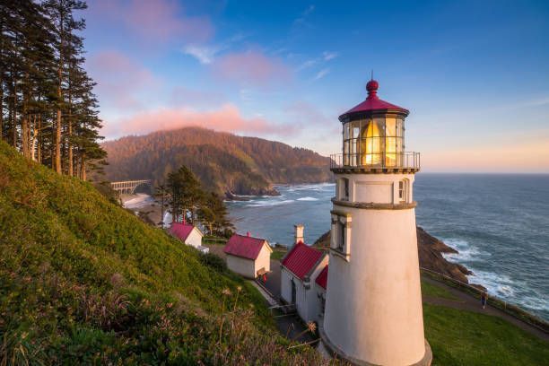 A lighthouse is sitting on top of a hill overlooking the ocean.