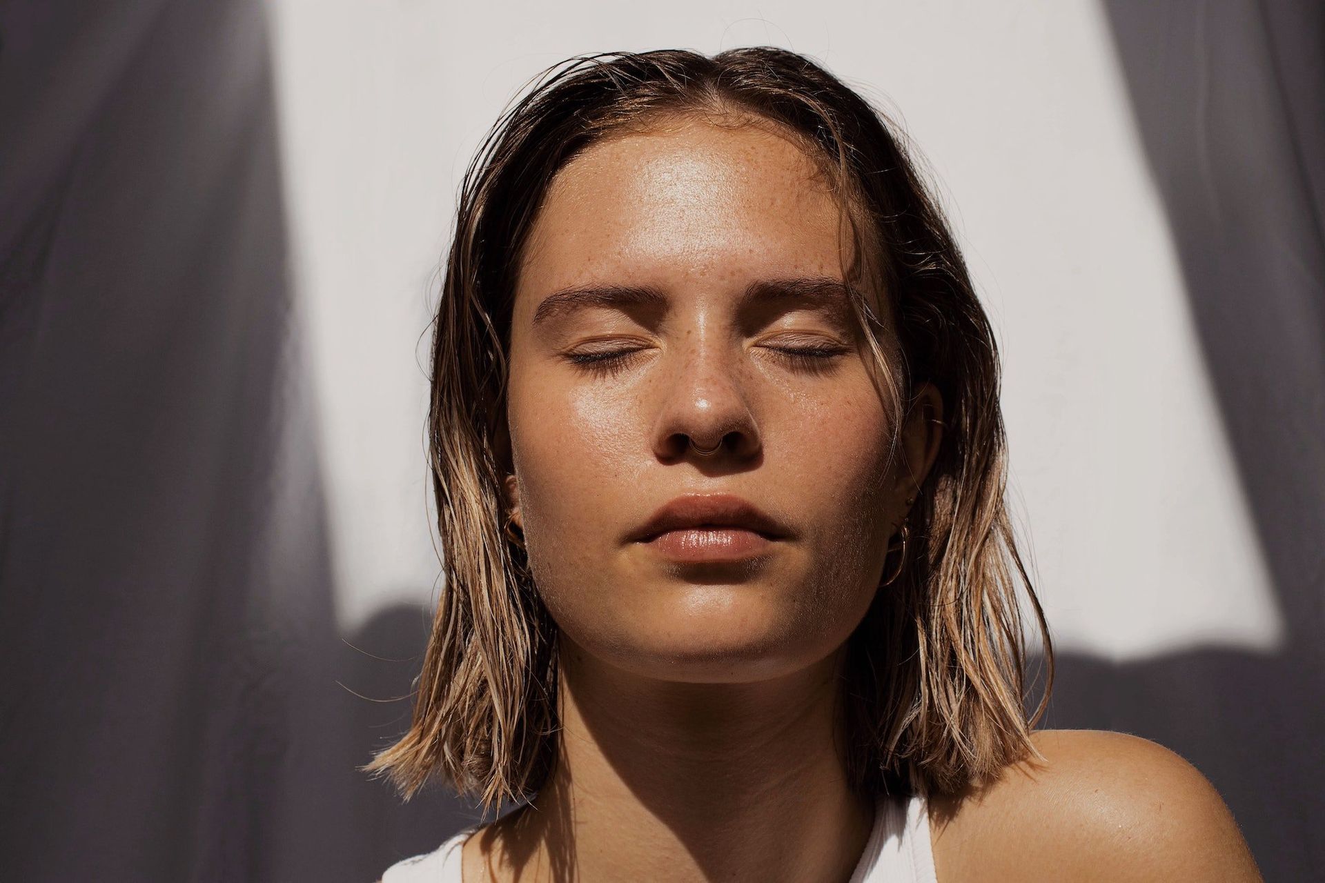 A close up of a woman 's face with her eyes closed.