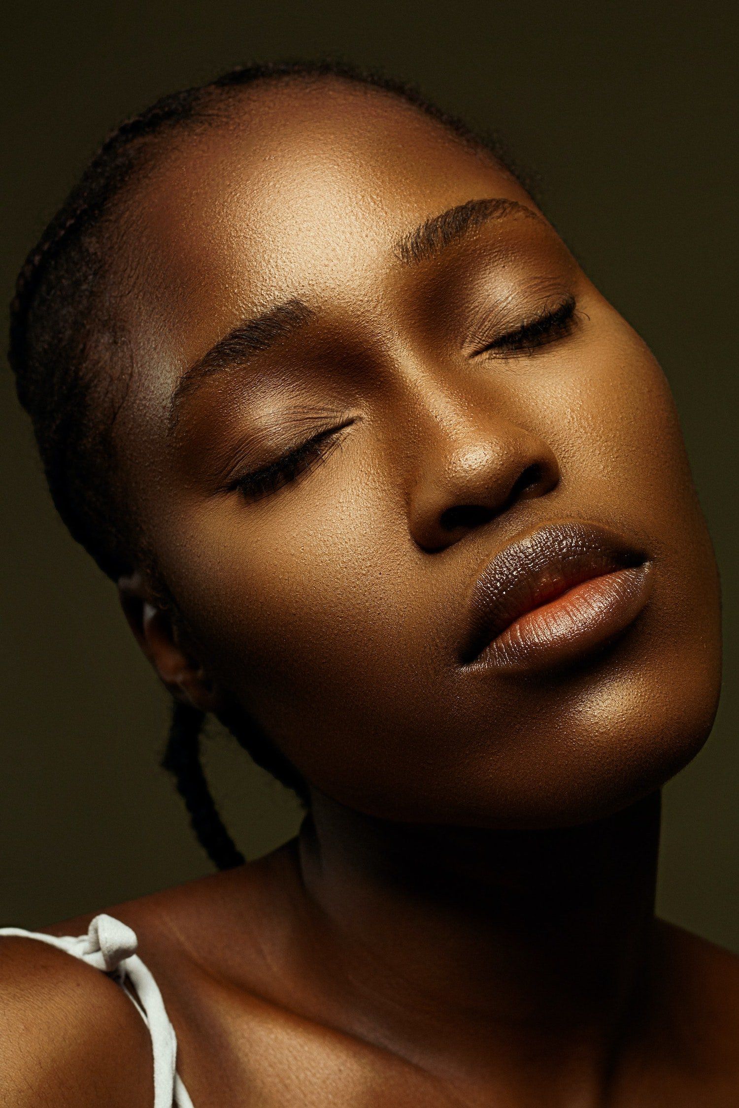 A close up of a woman 's face with her eyes closed.