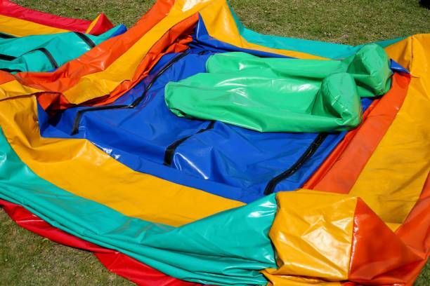 Colorful deflated inflatable play structure with red, yellow, green, and blue panels on grass