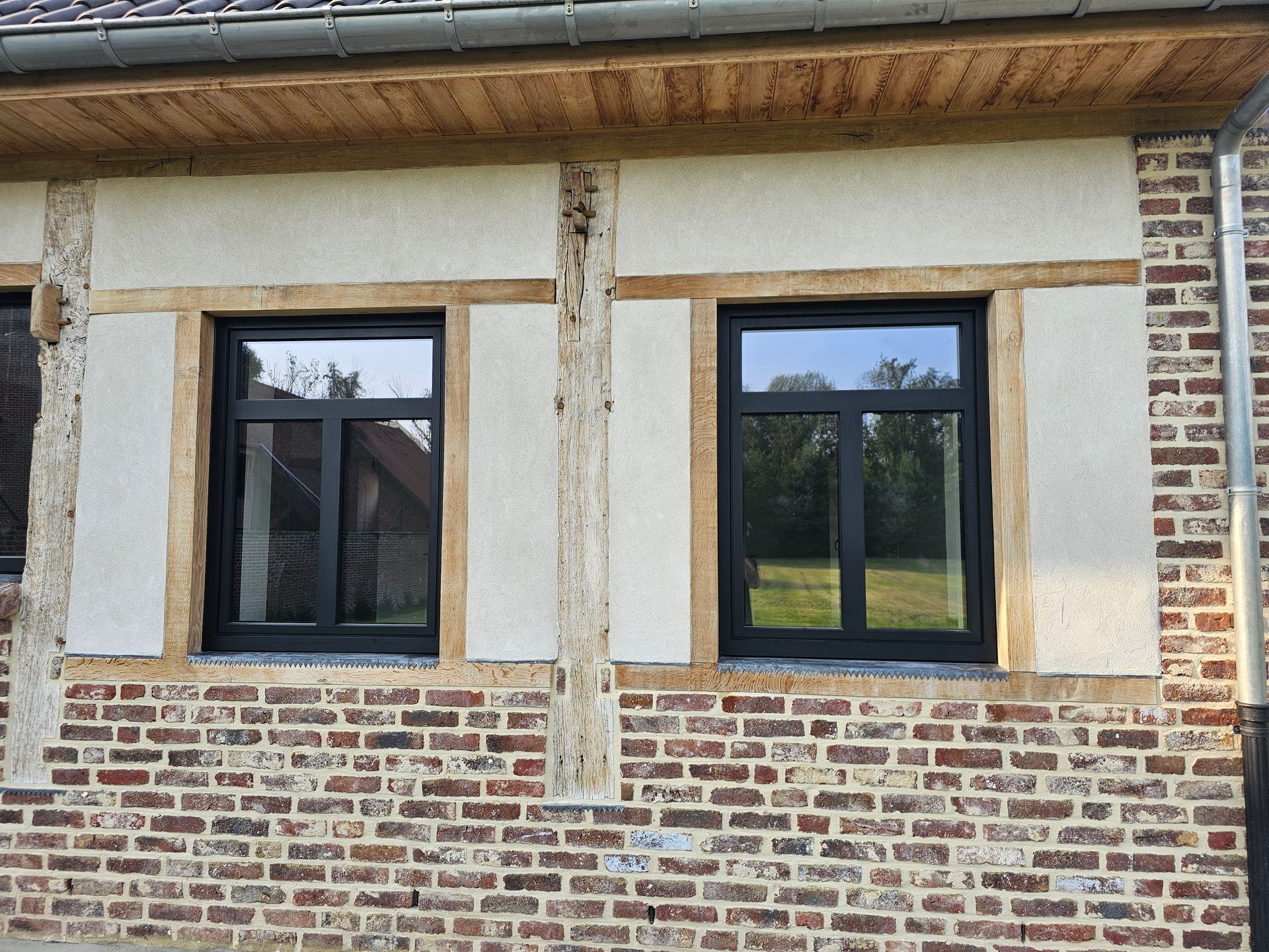 Gerenoveerde voormalige schuur in Brustem met zwarte aluminium ramen tussen eiken balken