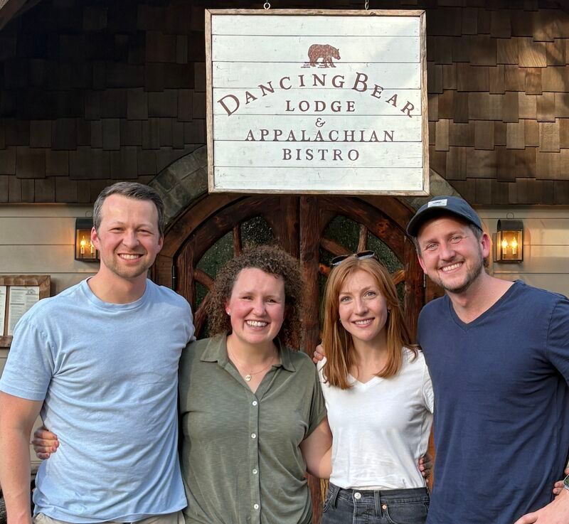 The founders stand outside Dancing Bear Lodge Appalachian Bistro sign.
