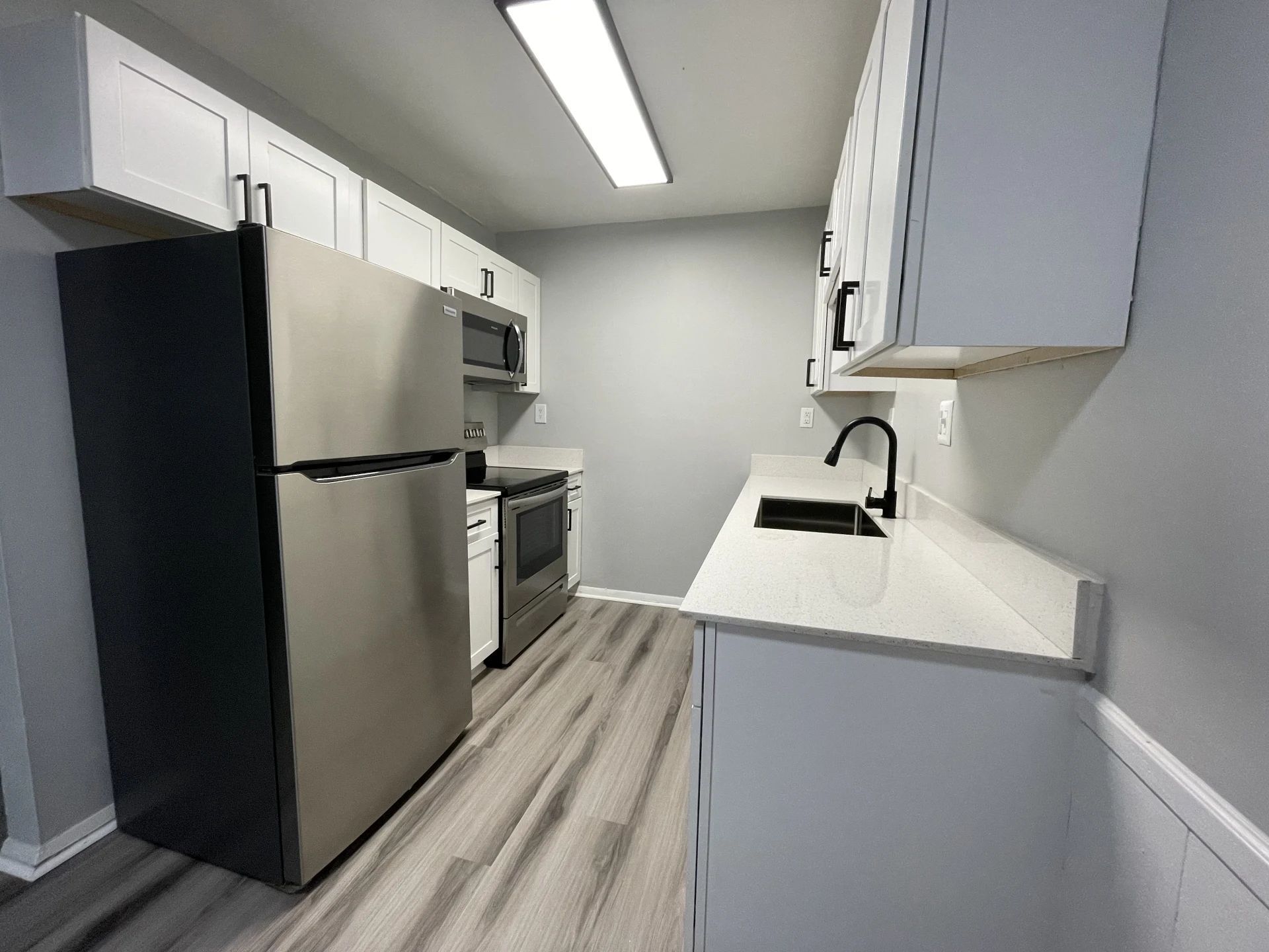A kitchen with stainless steel appliances and white cabinets