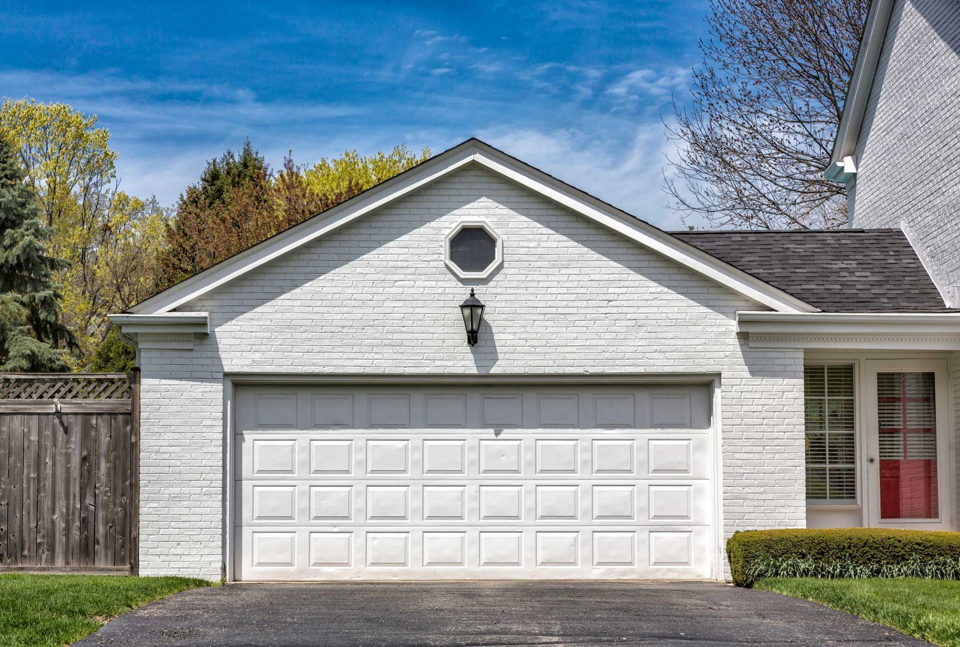 A white house with a large garage and a driveway