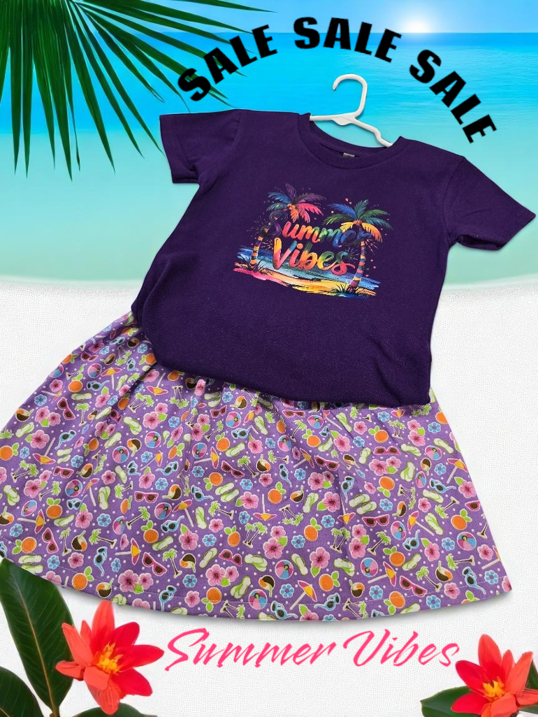 A purple shirt with a summer graphic and a matching floral skirt on a beach background with 