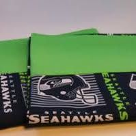Seattle Seahawks fabric with a bright green top section and a navy blue bottom section featuring the team helmet and name.