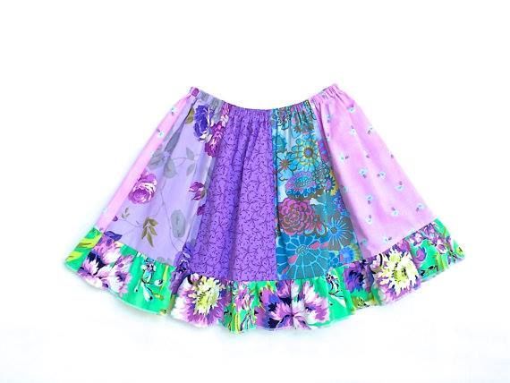 A colorful, knee-length patchwork skirt made of various floral and patterned fabrics in shades of purple, blue, and green.