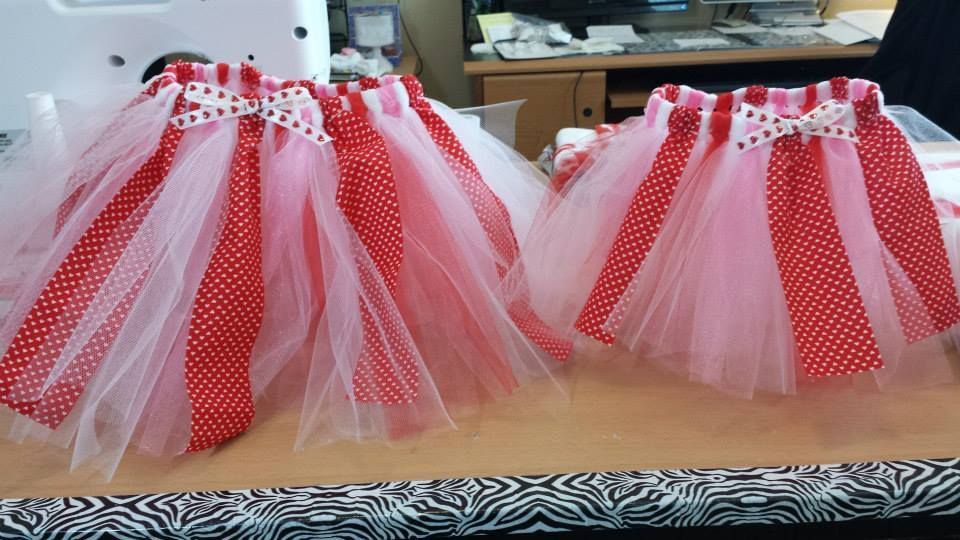 Two handmade tulle skirts in red and white polka dot patterns sit on a table.