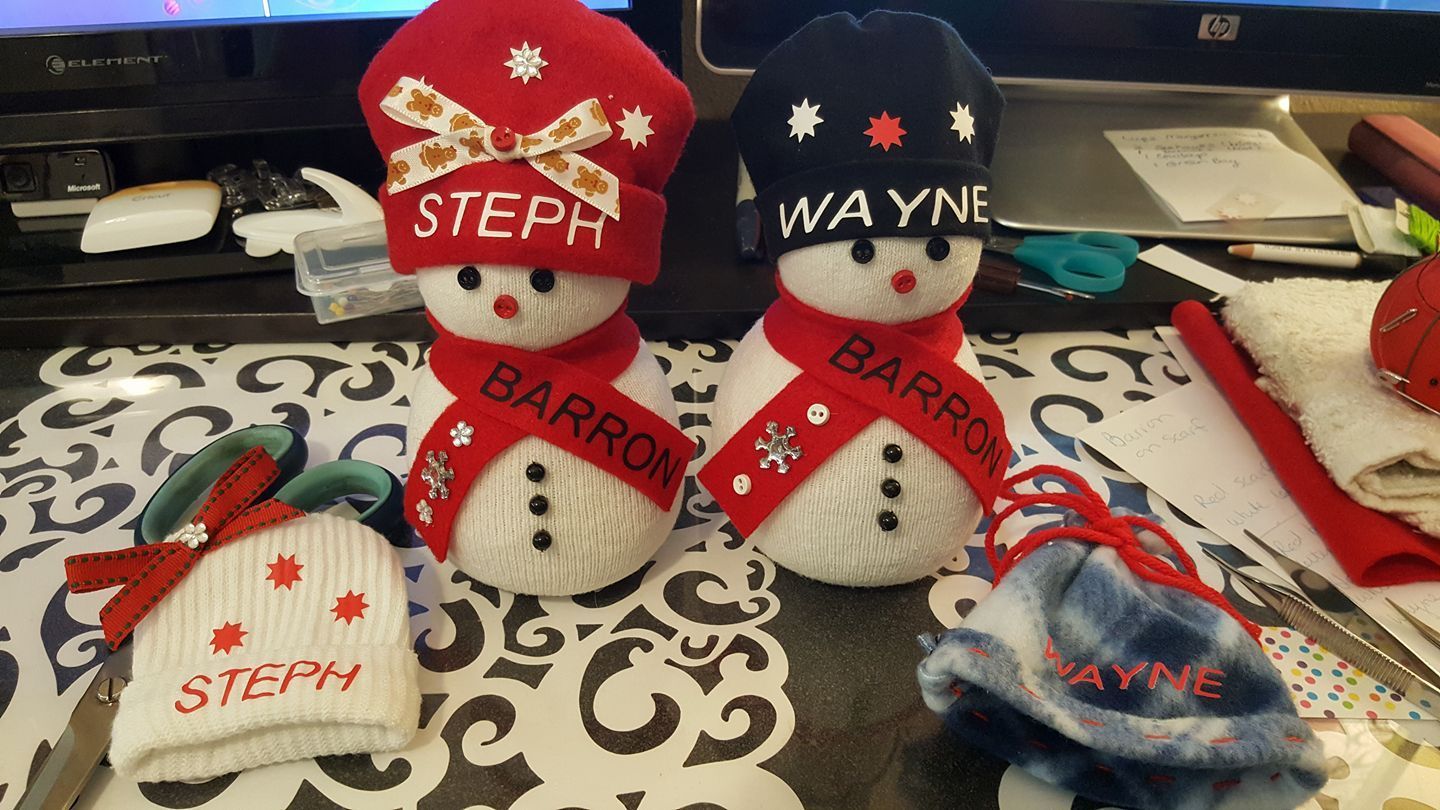 Two handmade sock snowmen labeled 
