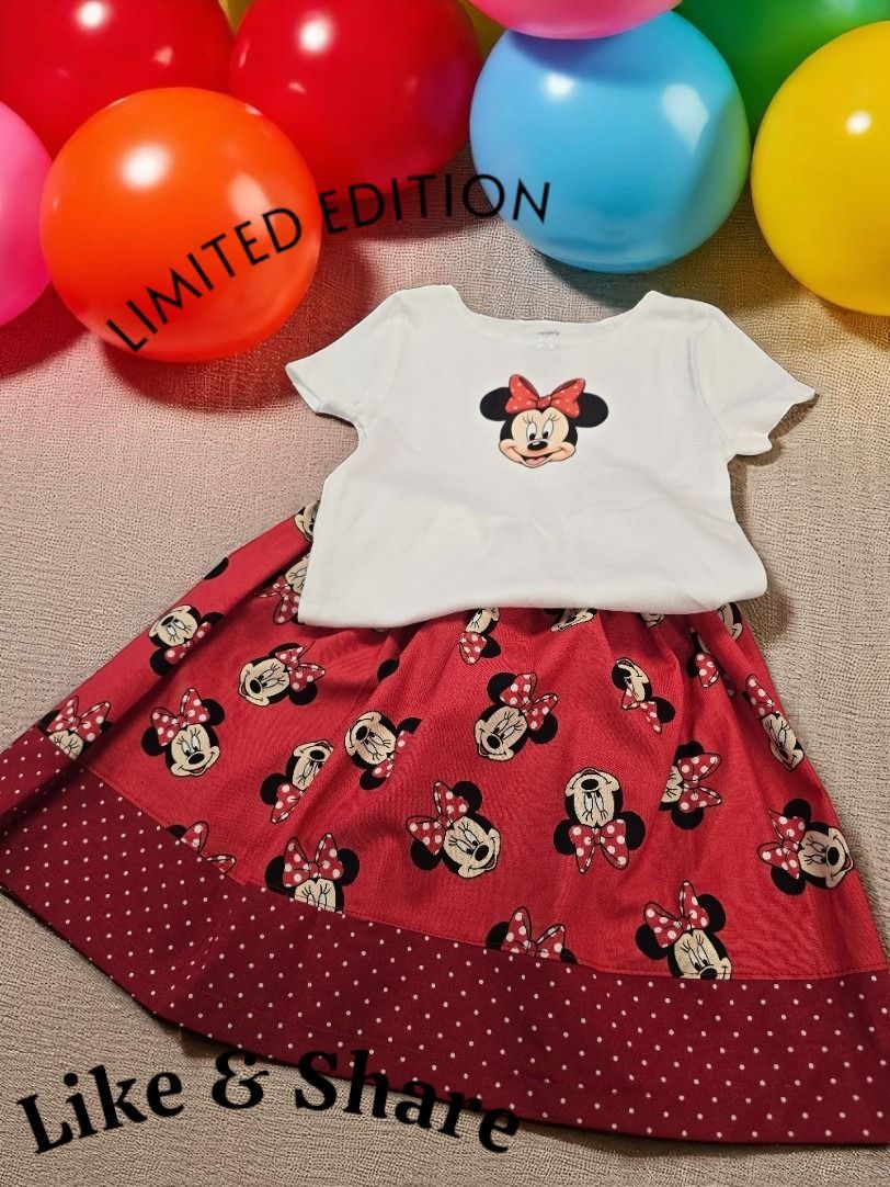 A Minnie Mouse themed outfit featuring a white shirt and red patterned skirt, surrounded by colorful balloons.